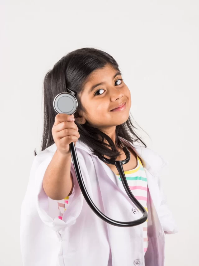 cute-little-indian-girl-doctor-with-stethoscope-while-wearing-doctor-s-uniform-standing-isolated-white-background